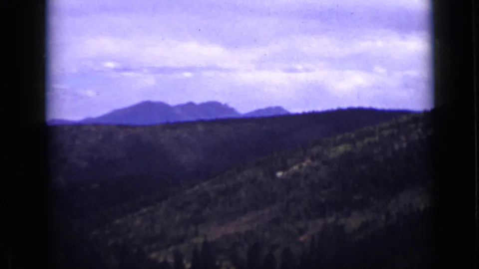 1939 Colorado 8mm frame with layered mountain ridges, rolling forested hills, and purple-blue color cast.