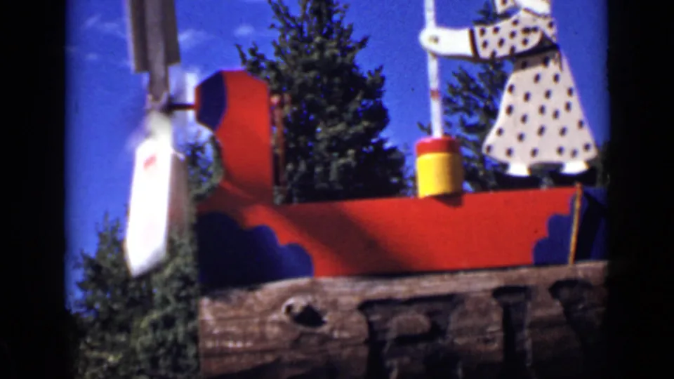 1939 Colorado 8mm frame showing the painted windmill structure with red and blue panels, white moving part, and butter-churning figure.