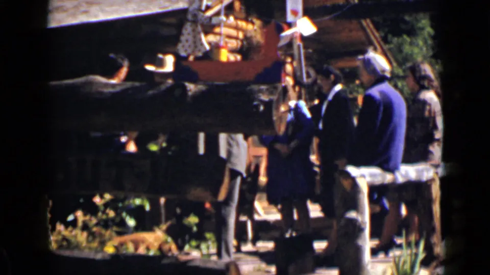 Several adults stand near a rustic outdoor display or seating area in the same 1939 Colorado home-movie sequence.