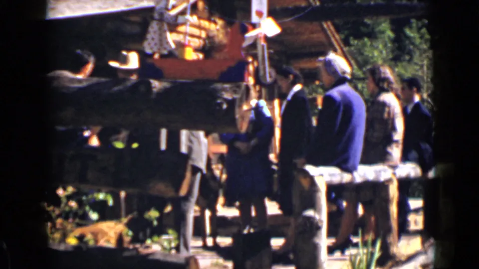 Adults in mid-century clothing stand beside benches and a rustic display area in 1939 Colorado home-movie footage.
