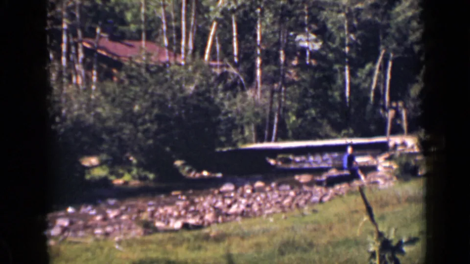 The final frame looks across a creek toward trees, a small bridge, and a rustic structure in Colorado.