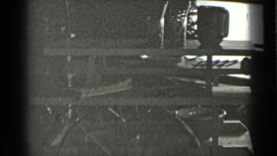 1939 New York 8mm frame showing a dim public interior detail with railings, flooring, and a bright window or opening above.