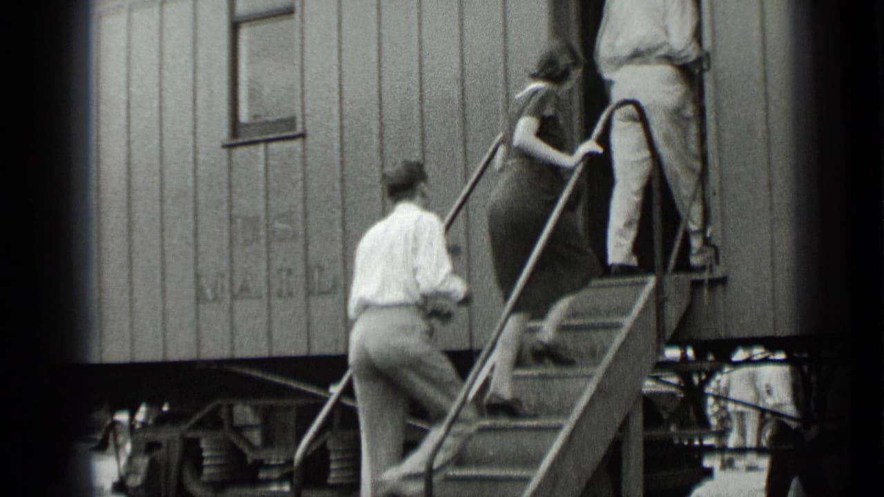 Passengers in late-1930s clothing ascend steps into an open U.S. Mail railcar doorway in New York.