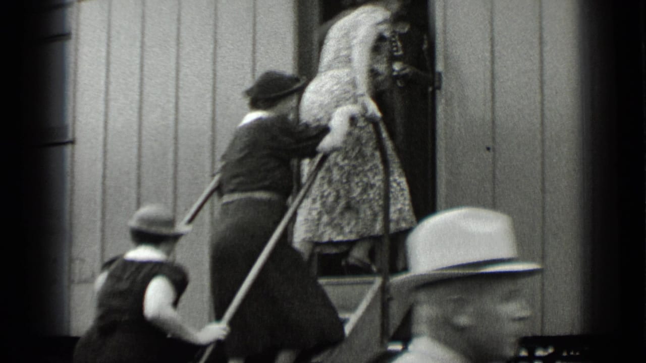 Women continue up the rail-car steps while a hat-wearing passenger passes in the foreground.