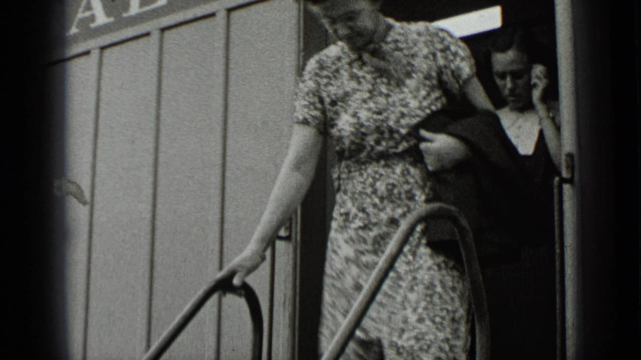 Woman in patterned dress steps down metal ride stairs as another woman stands behind her.