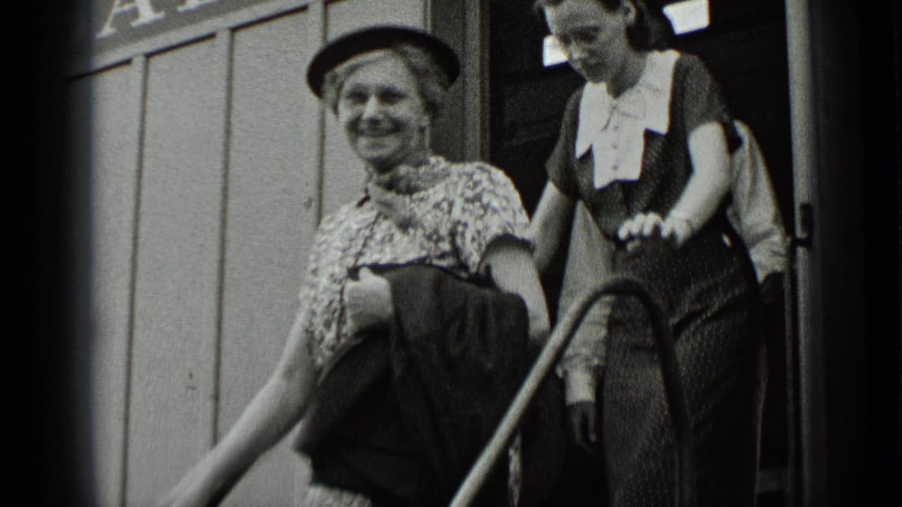 A smiling woman in a hat leaves a fair ride in New York, followed by a younger woman in a dark dress with a white collar.