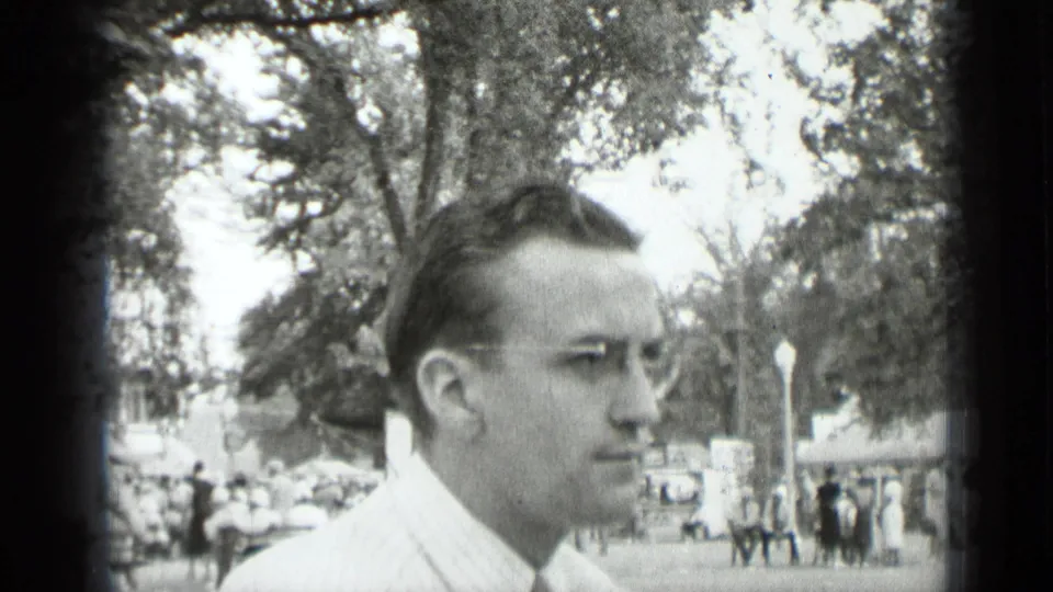 A man in a light shirt and glasses appears in profile in the same 1939 New York park setting, looking away from the camera.