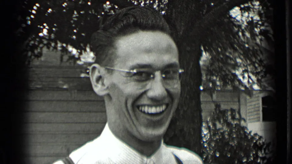 Young man in glasses laughs in a New York backyard in 1939 black-and-white 8mm home-movie footage.