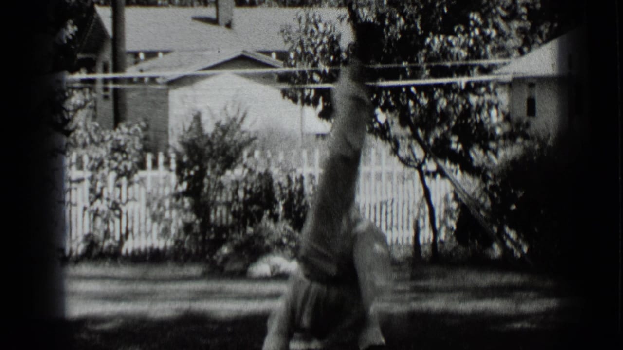 Boy upside down during a handstand on a backyard lawn.