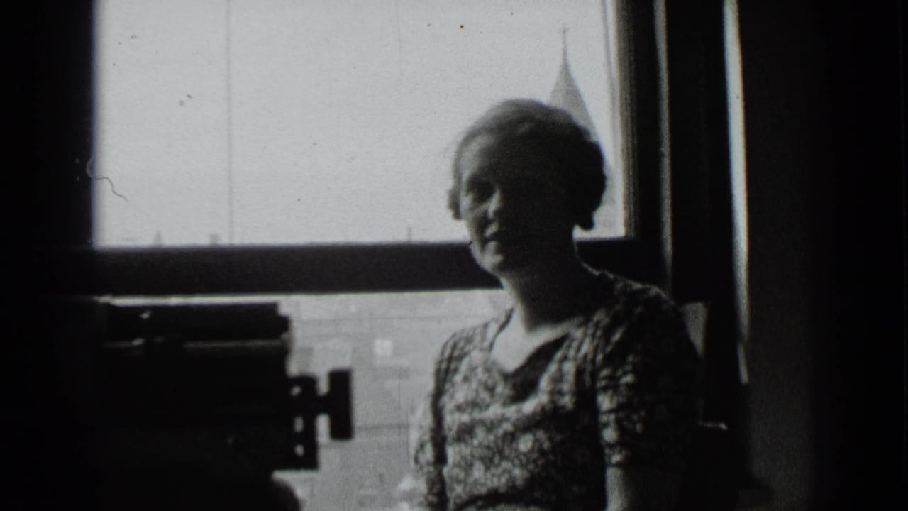 Woman stands in silhouette beside a window, with a dark typewriter shape at left.