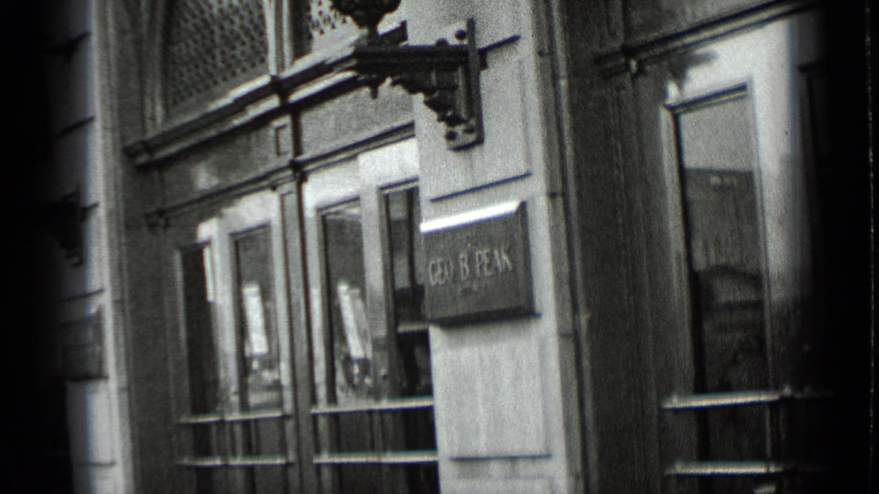 Building entrance with glass doors, wall sconces, and a plaque near the doorway.
