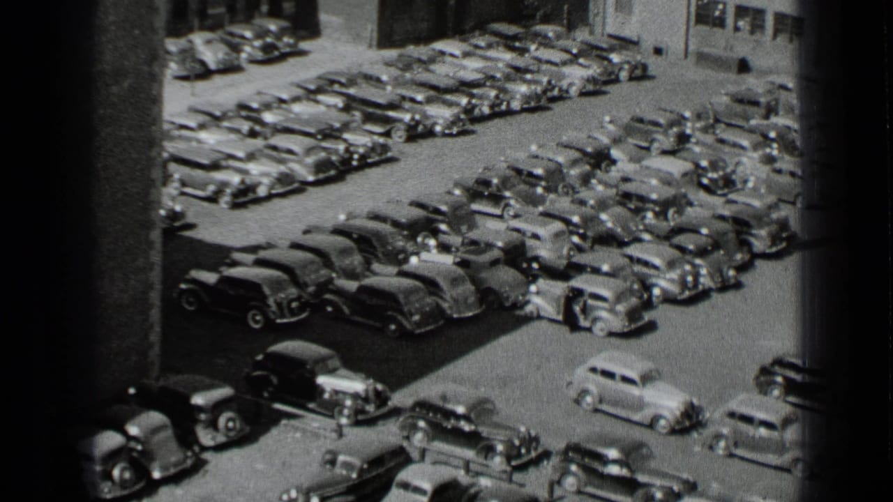High-angle view of many 1930s cars parked closely in a yard.