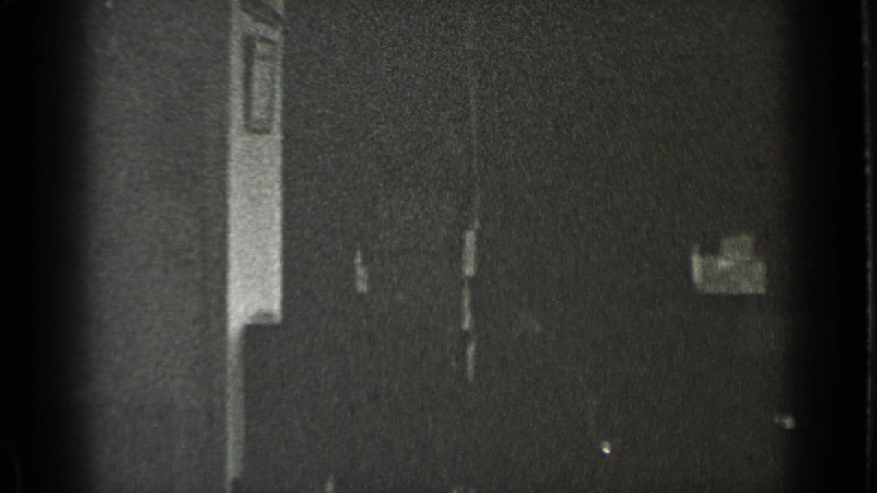 Dark, soft frame with a partial interior wall and faint office doorway detail.