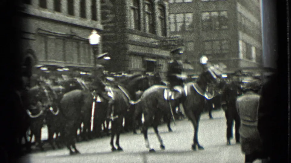1939 New York street footage shows mounted uniformed officers on horses with onlookers at the frame edge.