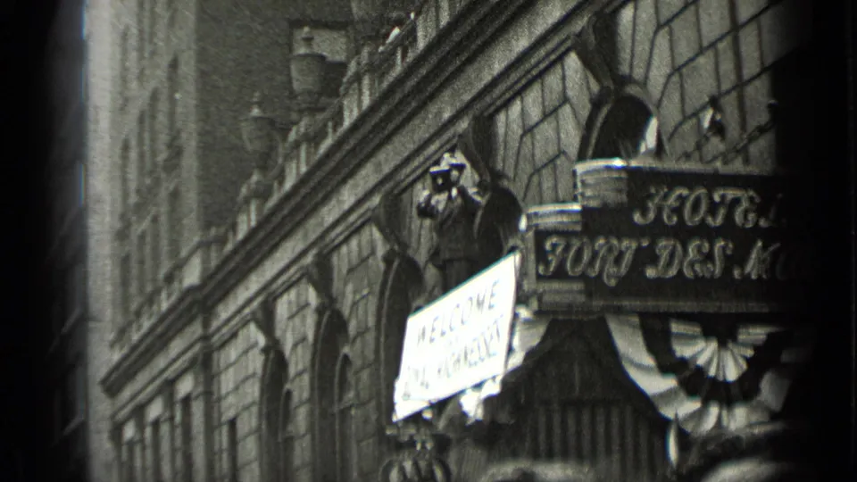 1939 New York street view of a hotel frontage with a visible sign, welcome placard, decorative facade, and a photographer near the entrance.