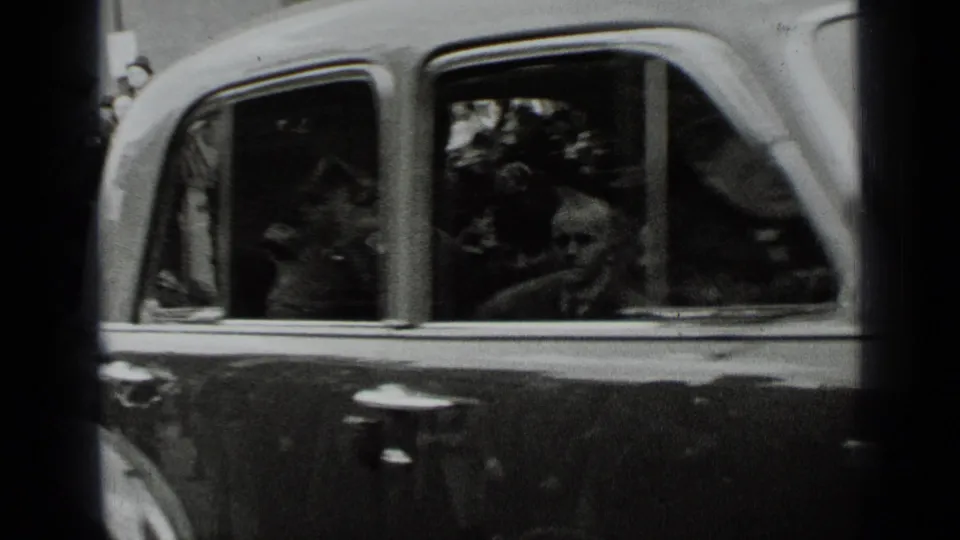 1939 New York view of a classic car side, with occupants and reflected spectators visible through the windows.