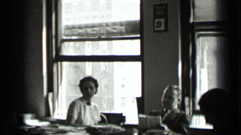 1939 New York office view showing women seated by large windows, with papers and equipment spread across desks.