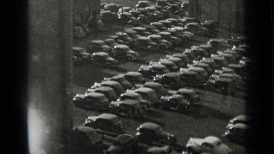 1939 New York home-movie frame showing a high-angle view over a densely packed lot of parked automobiles.