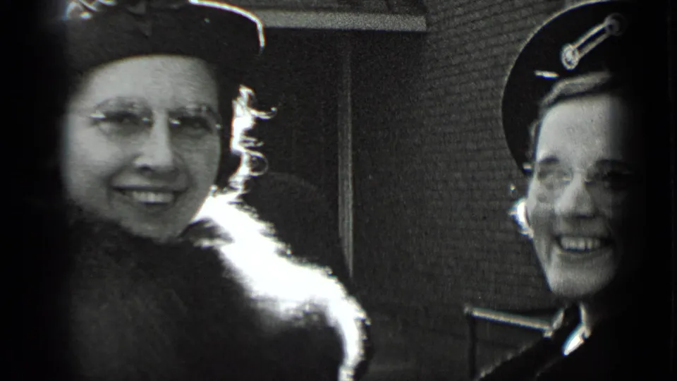 Close-up of two smiling women in 1939 New York footage, with one wearing a uniform-style cap and both framed by soft 8mm film edges.