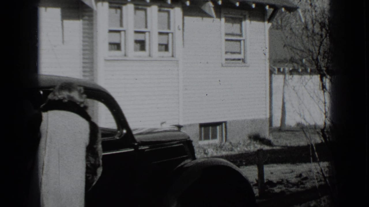 One woman bends near the car while another figure stands partly at the left edge.