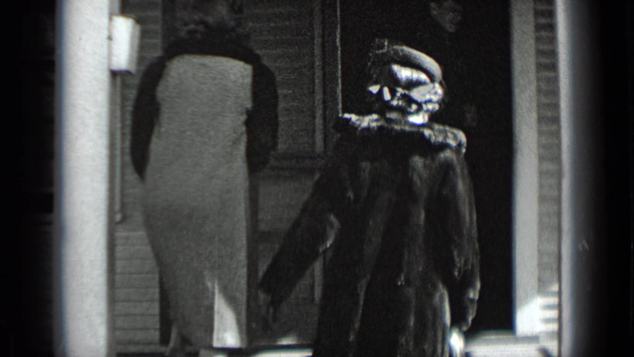 A light-coated woman reaches the entrance while a second woman in a dark fur coat and hat approaches behind her.