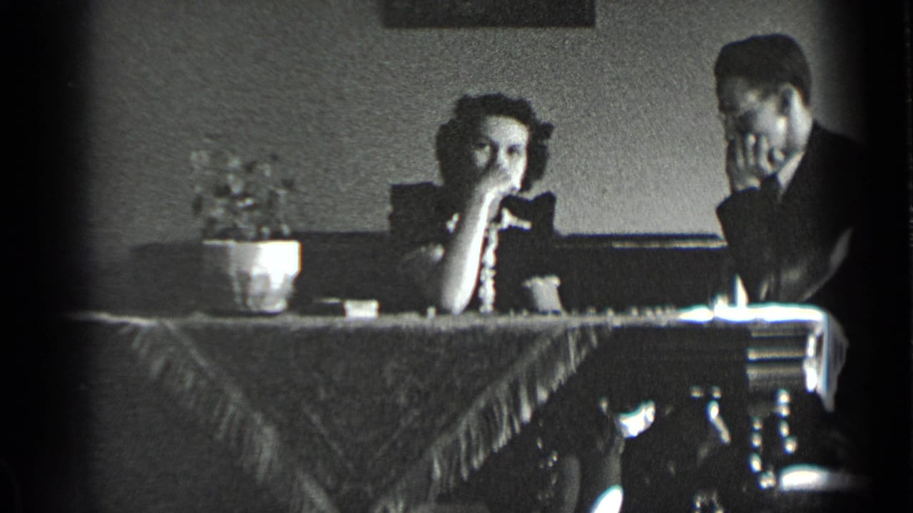 Woman rests her hand near her face while a man watches the chessboard.