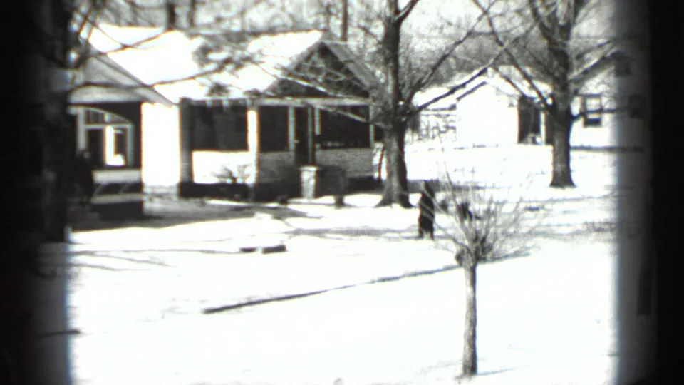 Winter residential street in New York, 1939 metadata, with snow on lawns, bare trees, houses, and a quiet road.