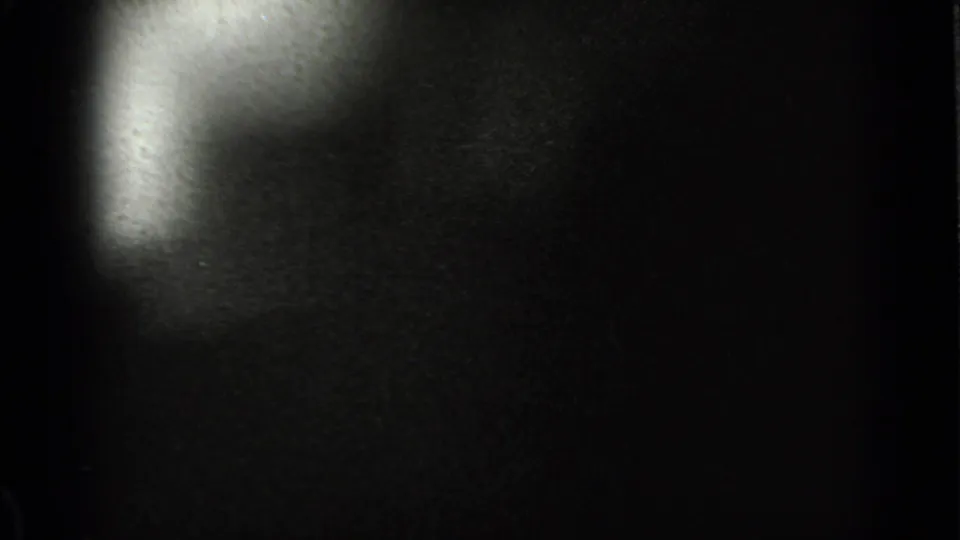 A dim final 8mm frame shows a bright curved exposure area against a dark field, with exterior detail mostly obscured.