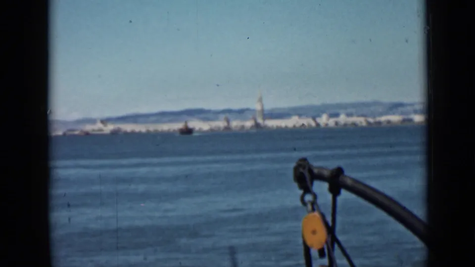 1939 San Francisco Bay frame looking toward the waterfront skyline, with bay water and dockside rigging in the foreground.