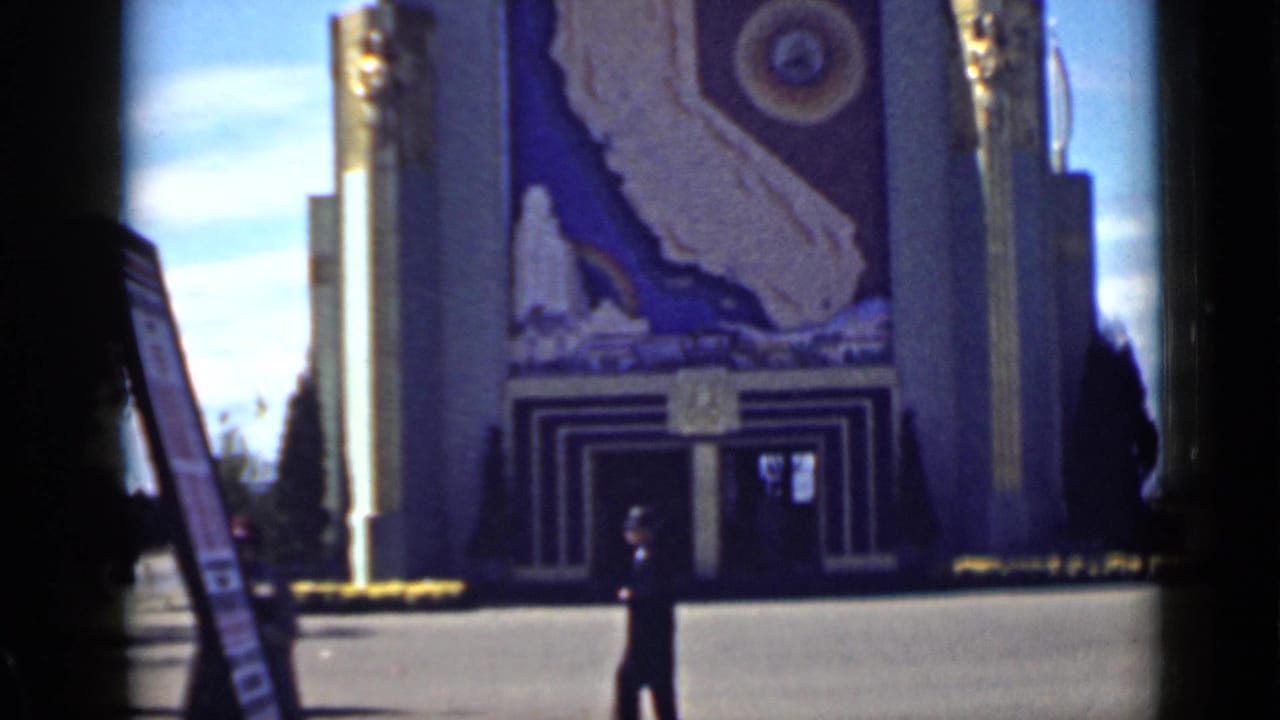 A single pedestrian stands near a mural-fronted pavilion entrance.