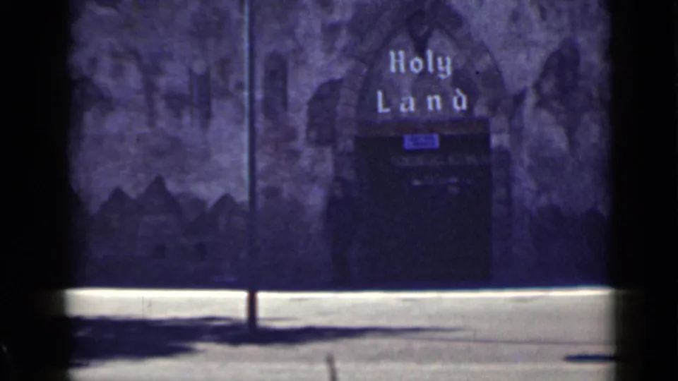 1939 San Francisco frame showing a Holy Land sign over an arched display entrance, filmed from the street.