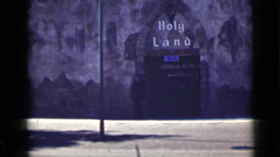 1939 San Francisco home-movie view of the Holy Land sign and dark arched entrance with painted backdrop.