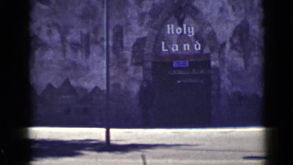 Street-level 1939 San Francisco frame of the Holy Land entrance display, with visible film borders and color shift.