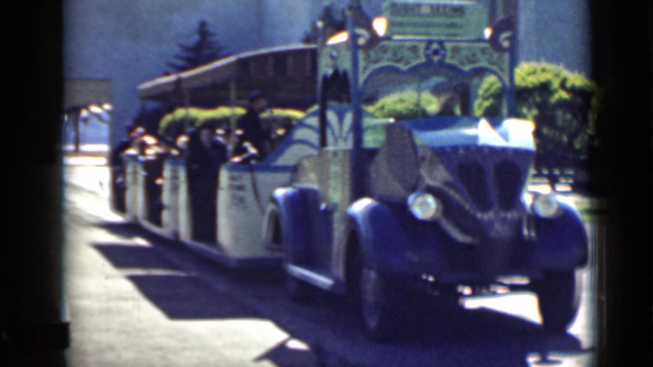 Tour tram closer to camera with passengers visible along the side.