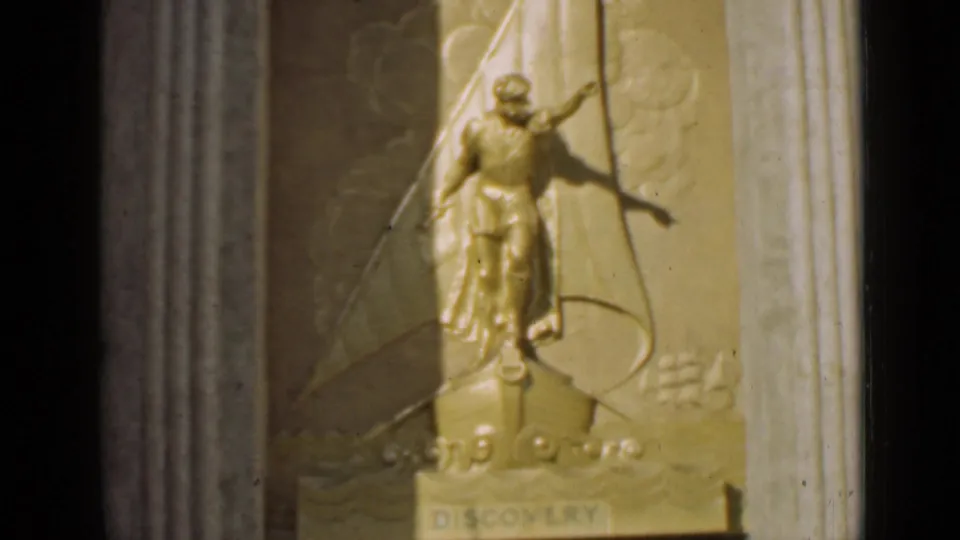 1939 San Francisco frame focusing on the gilded DISCOVERY sculpture, with the figure and sail motif held in soft 8mm focus.