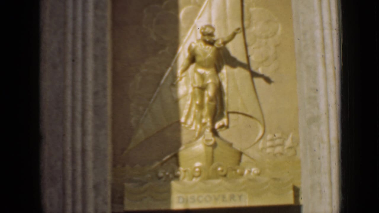 Gold relief figure above a ship-bow base with the word DISCOVERY below.