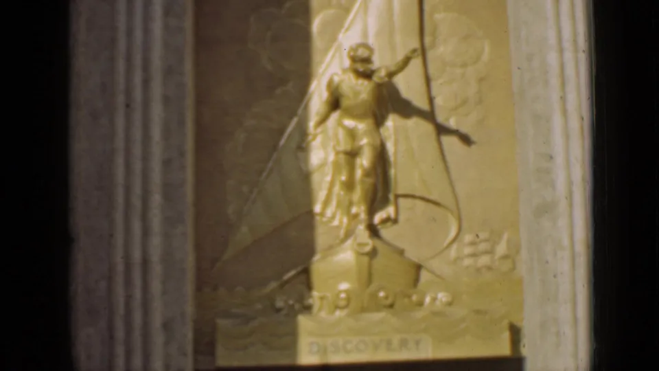 1939 San Francisco 8mm frame showing a gold-toned classical figure on a ship-bow relief with DISCOVERY visible below.
