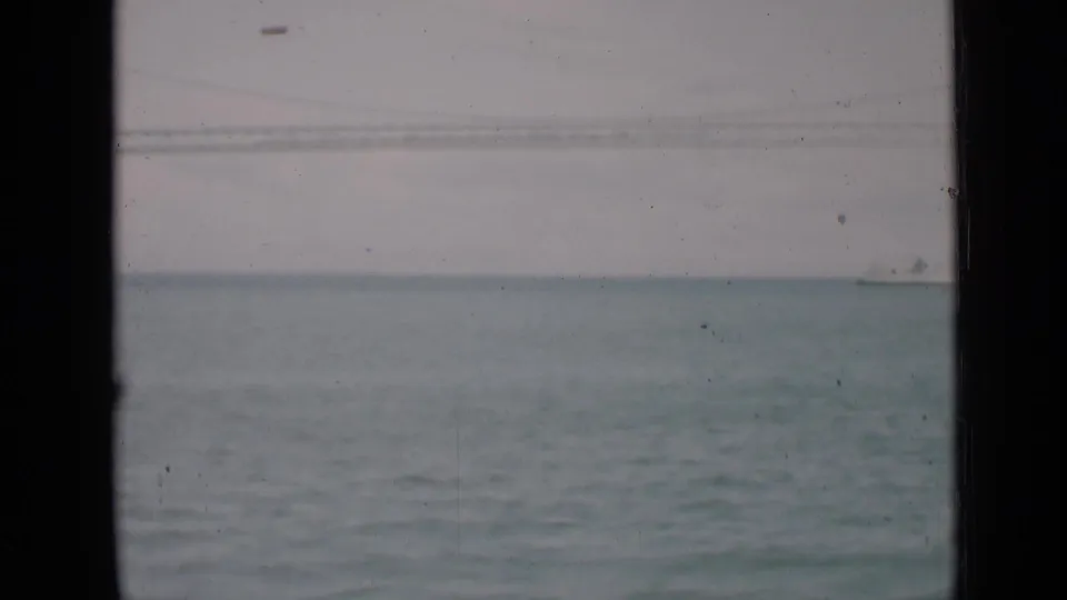 Soft 8mm view of San Francisco Bay water with faint bridge lines and a distant vessel near the horizon.