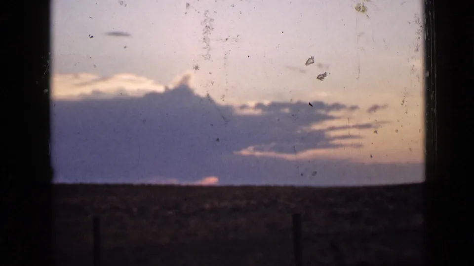 1939 Utah 8mm sunset frame showing cloud layers, a low sun glow, and open rural ground.
