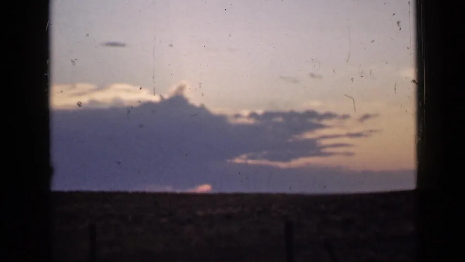 1939 Utah home-movie sunset with a broad cloud bank, flat horizon, and dark side framing.