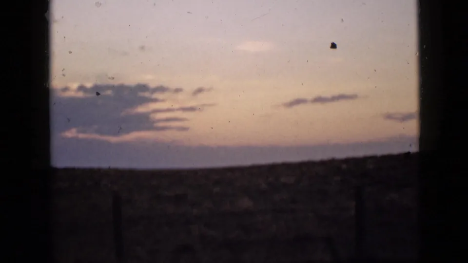 1939 Utah landscape frame showing an open horizon and lavender cloud band at dusk, viewed through dark vertical borders.