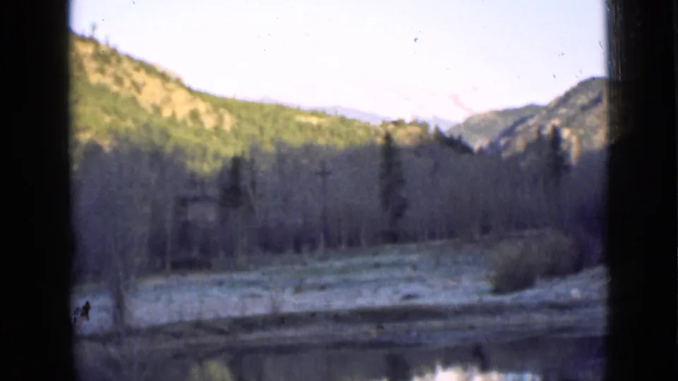 1939 Utah 8mm landscape showing a pond below wooded mountain slopes, bare trees, frost-toned ground, and distant snow-capped peaks.