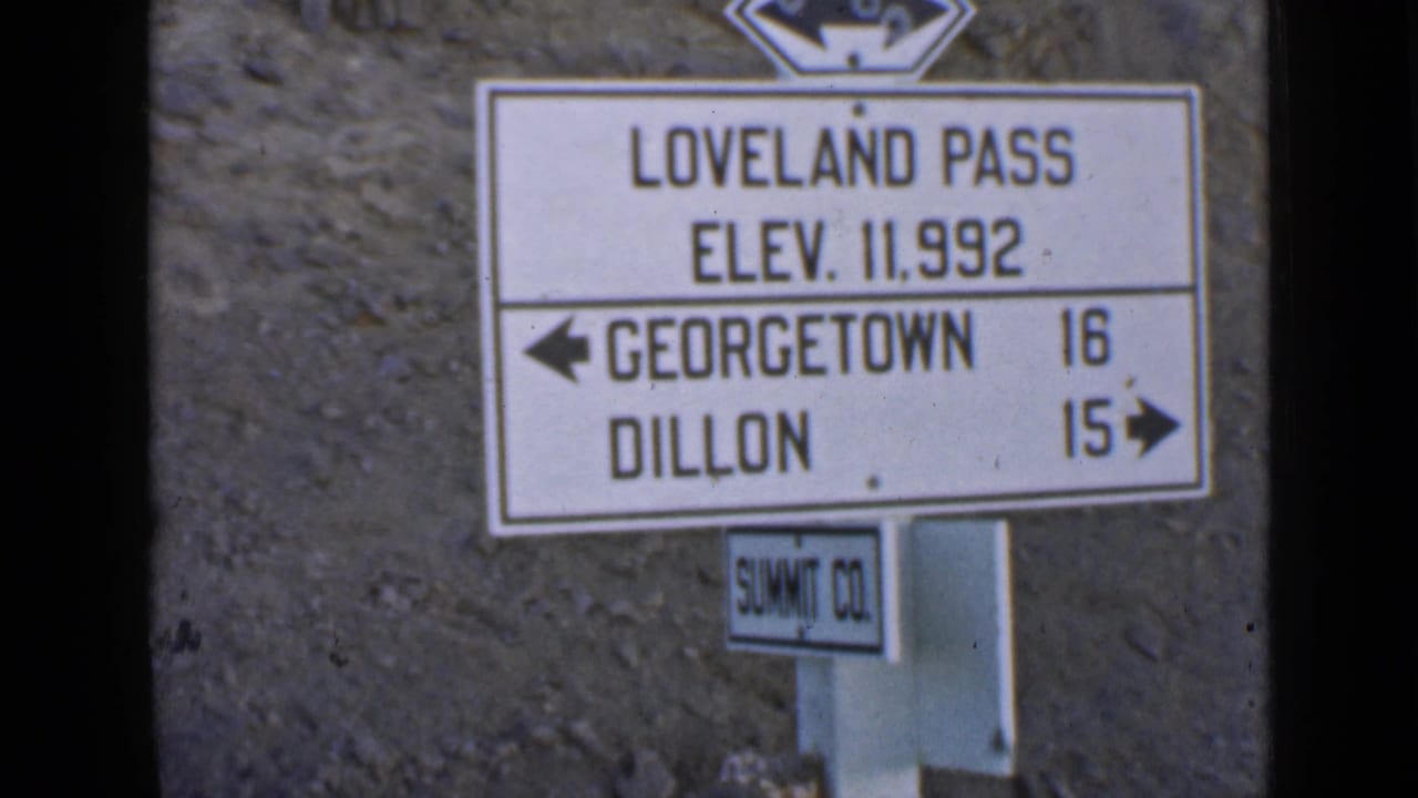 Roadside Loveland Pass sign with elevation and town directions.