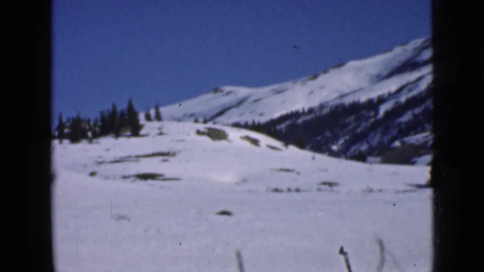 1939 Utah mountain landscape with broad snow cover, evergreen trees and ridged slopes seen on 8mm film.