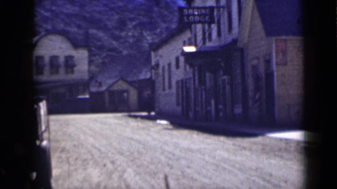 1939 Utah 8mm street view showing lodge-like buildings along a dusty road, including a visible Shrine Lodge sign.