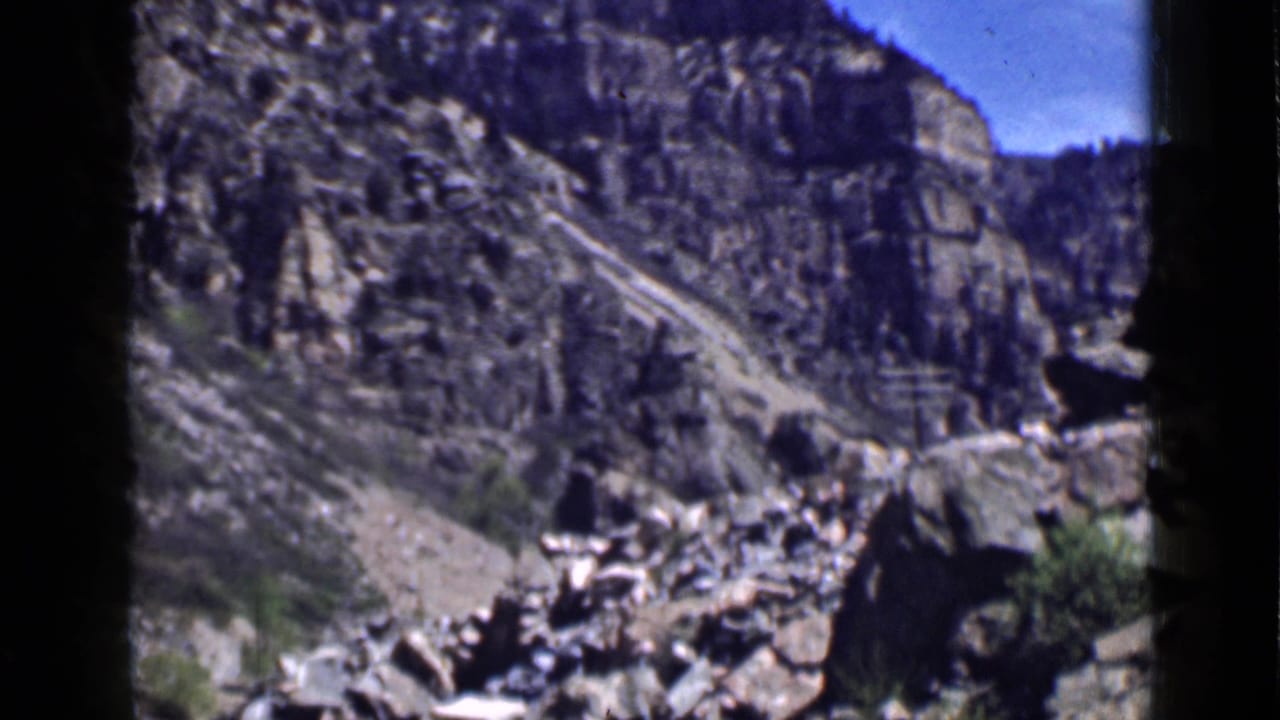 1939 Utah 8mm frame showing a rugged mountain slope and canyon terrain under bright blue sky.