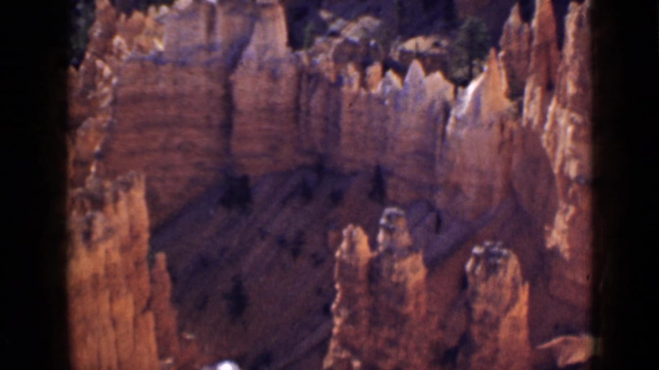 1939 Utah 8mm frame showing Bryce Canyon hoodoo formations, shadowed ravines, and warm red-orange rock walls.