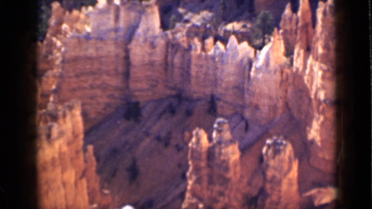 Canyon amphitheater with jagged hoodoos and dark 8mm frame edges.