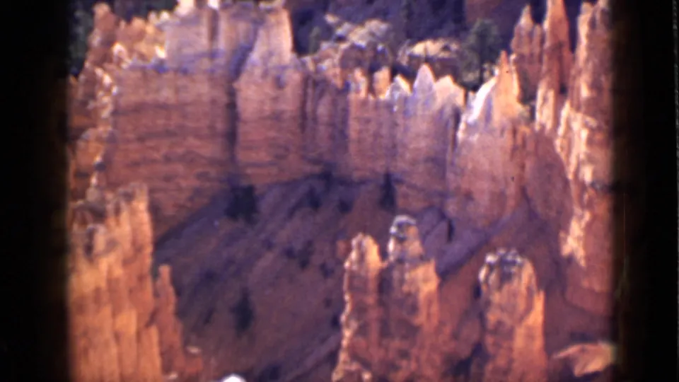 1939 Utah home-movie frame of Bryce Canyon’s jagged hoodoo formations, with sunlit cliffs and shadowed lower slopes.