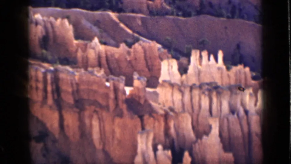 Utah canyon scenery from 1939, with pale hoodoo columns rising against reddish eroded rock layers.
